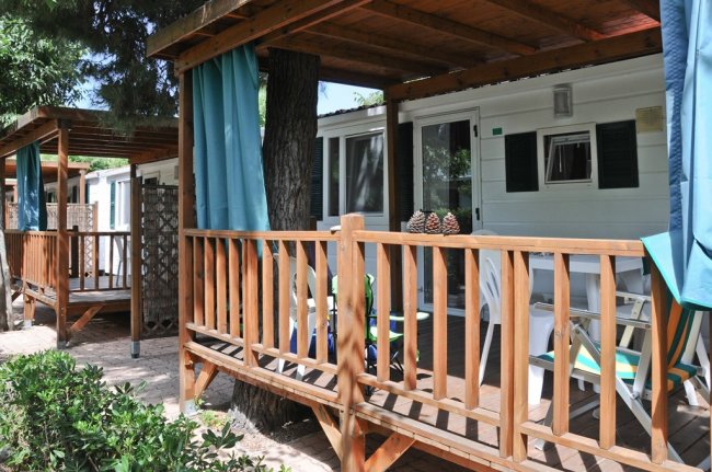 Bungalow con veranda in legno e sedie.