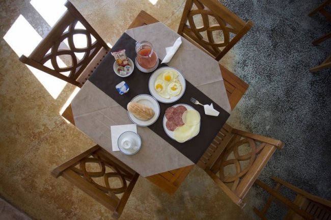 Tavolo con colazione, uova e salumi.