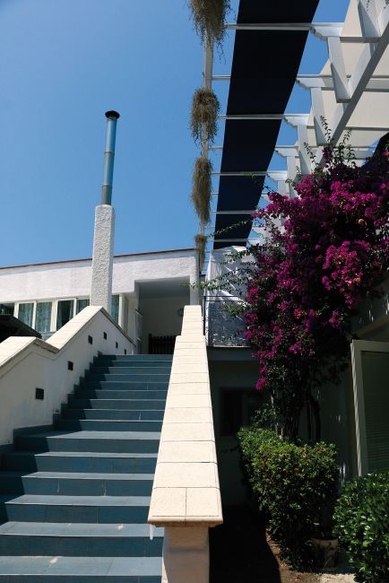 Scala esterna con fiori e piante rampicanti.