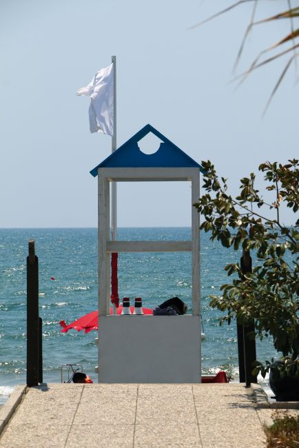 Torretta bianca e blu su passerella in spiaggia.
