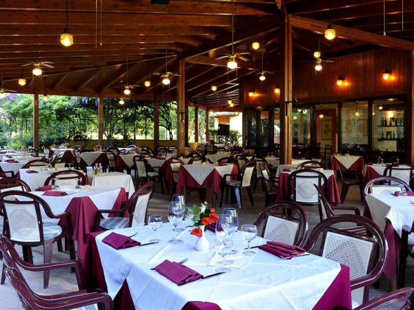 Ristorante all'aperto con tavoli apparecchiati.