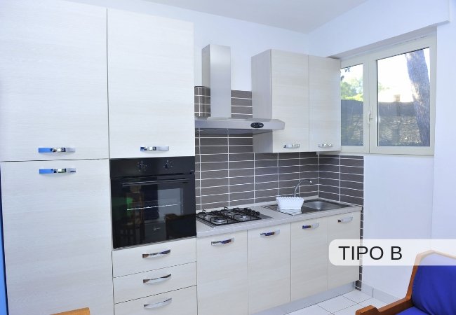 Cucina moderna con mobili chiari e forno.