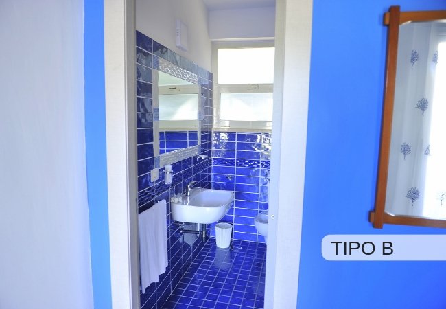 Bagno con piastrelle blu e lavandino bianco.