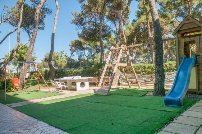 Area giochi con scivolo, altalena e tavolo da ping pong.