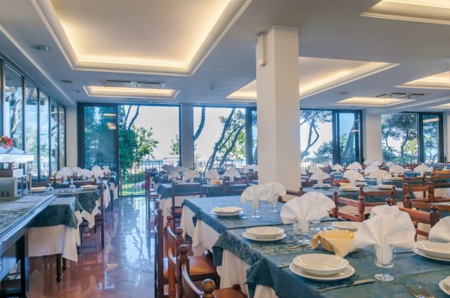 Sala da pranzo elegante con tavoli apparecchiati.