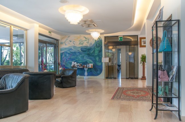 Atrio elegante con divani, vetrate e decorazioni.
