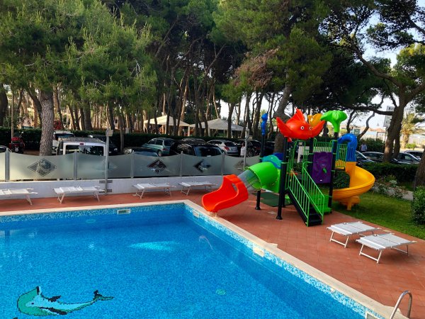 Piscina con scivolo colorato nelle vicinanze di alberi.
