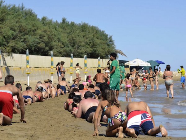 Persone sulla spiaggia partecipano a un'attività.