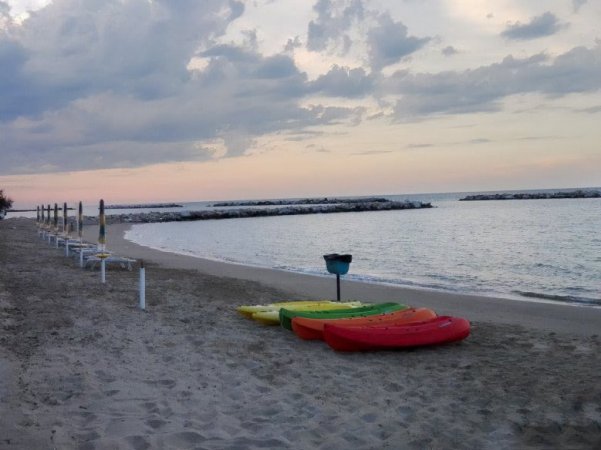 Spiaggia con canoe colorate al tramonto.
