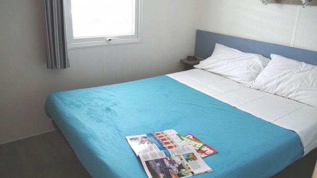 Camera matrimoniale con riviste sul letto.