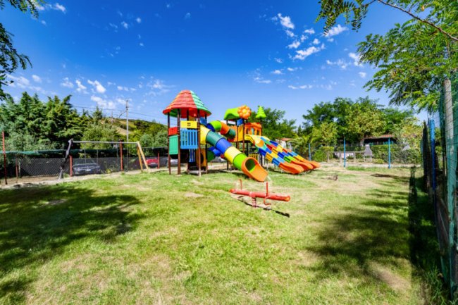 Parco giochi colorato su un prato verde.