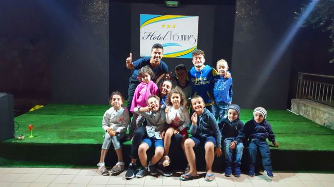 Un gruppo di persone sorride su un palco d'erba.
