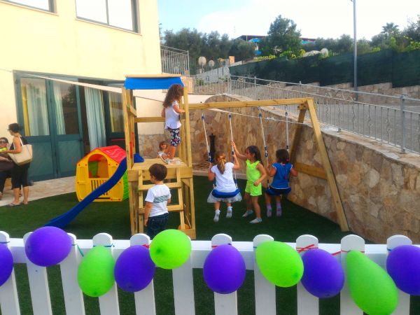 Bambini giocano su un'altalena in un parco giochi.