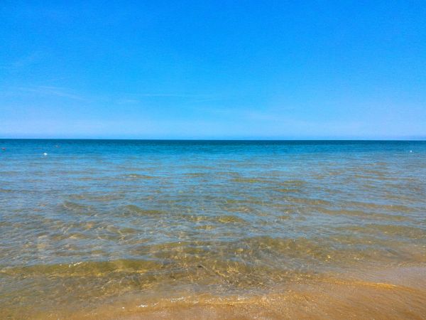Mare calmo sotto un cielo blu limpido.